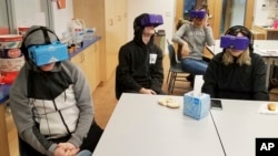In this Feb. 7, 2018 photo, students at the Berkeley Carroll School in the Brooklyn borough of New York use virtual reality headsets in their classroom. (AP Photo/Deepti Hajela)