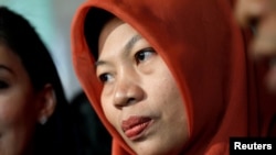 Baiq Nuril Maknun, a school bookkeeper who was jailed after she tried to report sexual harassment, reacts to journalists as she arrives at the Law and Human Rights Ministry office, in Jakarta, Indonesia, July 8, 2019.