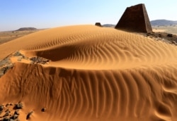 Creeping desert sands surround the Royal Cemeteries of Meroe Pyramids in Begrawiya at River Nile State, Sudan, Nov. 10, 2019.