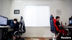 Foxton Harding, left and Adison Pucci, both 12, who attend Northshore Middle School, which has moved to online schooling for two weeks due to coronavirus concerns, work on school assignments at their home in Bothell, Washington, March 11, 2020.