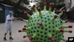 Indian car designer K. Sudhakar Yadav stands beside a coronavirus-themed car he made as part of an awareness campaign aimed at preventing the spread of the virus, in Hyderabad, India, April 7, 2020.