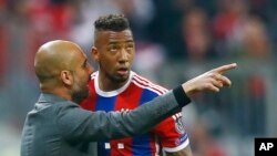 L'entraîneur du Bayern Pep Guardiola, à gauche, donne des instructions a son joueur Jerome Boateng lors d’un match de la Ligue des Champions entre le Bayern Munich et le FC Porto à l'Allianz Arena, à Munich, Allemagne, 21 avril 2015. (AP Photo / Matthias Schrader )