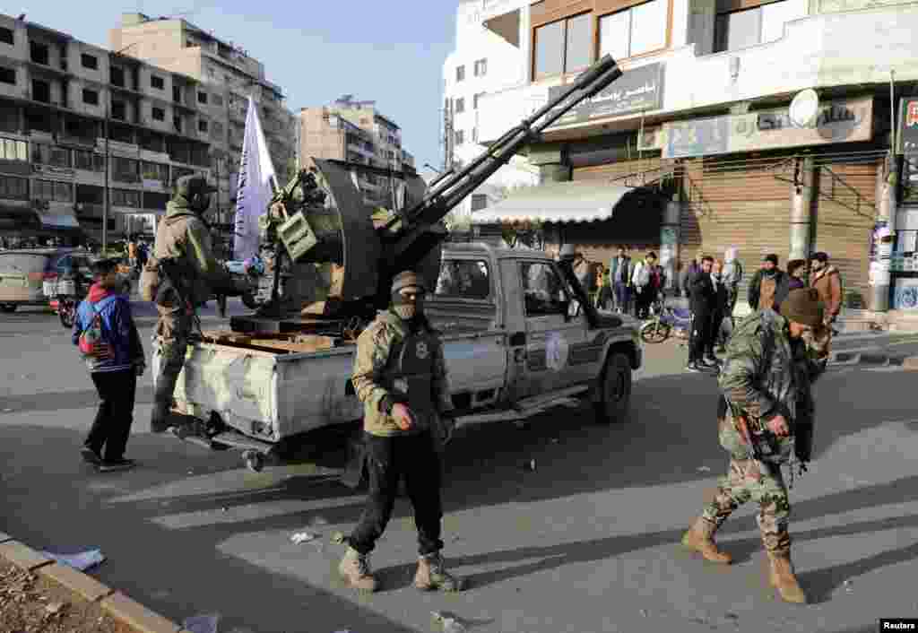 Fighters of the ruling Syrian body patrol the street, after dissent surfaced in the city of Homs, north of Damascus. State media reported that police imposed an overnight curfew, following unrest linked to demonstrations that residents said were led by members of the Alawite and Shiite religious communities.