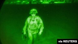 U.S. Army Major General Chris Donahue, commander of the 82nd Airborne Division, steps on board a C-17 transport plane as the last U.S. service member to leave Hamid Karzai International Airport in Kabul, Afghanistan, Aug. 31, 2021.
