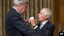 Senate Budget Committee members Sen. Sheldon Whitehouse, D-R.I., left, and Sen. Bob Corker, R-Tenn., talk before the start of a Senate Budget Committee hearing in Washington, Nov. 28, 2017
