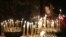 FILE - A woman lights a candle during a religious service at a church in Kyiv, February 23, 2014. 