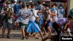 អ្នកគាំទ្រ​របប​យោធា ប្រឈមមុខនឹង​ក្រុម​បាតុករ​គាំទ្រ​លទ្ធិប្រជាធិបតេយ្យ ក្នុង​អំឡុងពេល​ការប្រមូលផ្តុំគ្នា​គាំទ្រ​យោធា​នៅ​ទីក្រុង​រ៉ង់ហ្គូន​នៃ​ប្រទេស​មីយ៉ាន់ម៉ា​ នៅ​ថ្ងៃទី២៥ ខែកុម្ភៈ ឆ្នាំ២០២១។