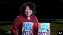 Supreme Court Associate Justice Sonia Sotomayor holds her new children's book "Just Help!" in Washington, Jan. 19, 2022.
