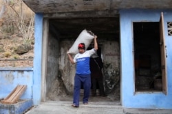 FILE - A bat guano collector carries a bag as he gets out of a bat cave at Wat Khao Chong Phran in Ratchaburi, Thailand, March 13, 2020.