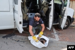 Član deminerskog odreda izraelske policije sakuplja ostatke rakete koju su palestinski militanti ispalili na Izrael, u Hercliji, nedaleko od Tel Aviva, 26. maja 2024.