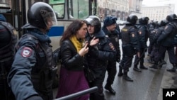 Polisi menahan seorang perempuan di jalan utama di Moskow, 2 April 2017.