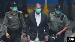 资料照：香港《壹传媒》创办人黎智英走向警车准备前往香港一家法院。(2020年12月12日)