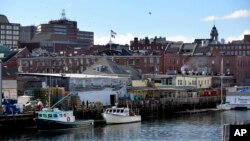 FILE - Fishing boats are tied up at a wharf on the waterfront in Portland, Maine, March 11, 2016. 