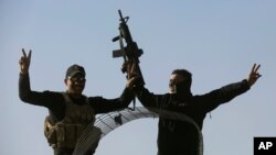 Iraqi special forces soldiers flash victory signs, as they arrive to relieve soldiers returning from the battlefield in Mosul, Iraq, Nov. 23, 2016. An airstrike by the U.S.-led coalition on Wednesday disabled the fourth bridge on the Tigris River in Mosul, leaving the northern Iraqi city with a single functioning bridge. 
