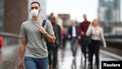 Seorang pelaju menyeberangi Jembatan London di tengah pandemi virus corona di London, Inggris, Selasa, 6 Juli 2021. (Foto: Hannah McKay/Reuters)