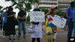 Two girls hold signs while waiting to get a glimpse of Yuto Horigome, the first Olympic gold medalist in skateboarding, outside the Ariake Urban Sports Park during the 2020 Summer Olympics, July 25, 2021, in Tokyo.
