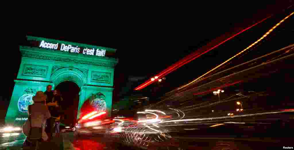 The Arc de Triomphe is illuminated in green with the words &quot;Paris Agreement is Done,&quot; to celebrate the Paris U.N. COP21 Climate Change agreement in Paris, France.