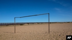 FILE - A soccer field is seen next tot the border fence that divides Mexico with the US, at a check point in San Luis Rio Colorado, Baja California state, Mexico.