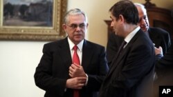 Greek Prime Minister Lucas Papademos (L) speaks with newly appointed Finance minister Philippos Sachinidis in Athens on March 21, 2012.