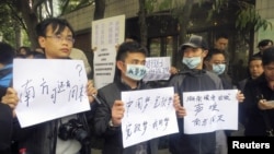 1月8日，示威者手持标语牌站在广州南方周末报社的总部的外面