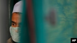 FILE - In this April 21, 2020, photo, a Muslim man, among 29 people arrested by Indian authorities, awaits transport to a Prayagraj, India, prison. Muslims in India face stigma after the government blamed an Islamic meeting for a coronavirus surge.