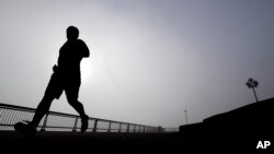 FILE - A man jogs at Pier A Park in Hoboken, New Jersey, Jan. 15, 2014. Atherosclerosis, or calcium deposits, in the cardiac arteries of young people have been found to dramatically shorten life expectancy, a new study found.