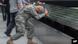 Army Sgt. Edwin Morales prays during a ceremony at the World Trade Center site in New York, Sept. 11, 2015.