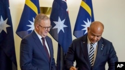 Perdana Menteri Australia Anthony Albanese menyaksikan Presiden Nauru David Adeang, (kanan), menandatangani buku tamu Gedung Parlemen Australia di Canberra, Senin, 9 Desember 2024. (Dominic Giannini/AAP Image via AP)