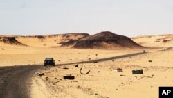 Une voiture roule le long de la route entre Sebha et Ubari, dans le sud-ouest de la Libye, le 24 décembre 2013.