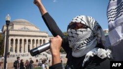 Пропалестинские демонстранты маршируют по кампусу Колумбийского университета, чтобы отметить первую годовщину войны между ХАМАС и Израилем в Нью-Йорке 7 октября 2024 года