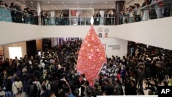 香港抗议者在圣诞节平安夜游行走过一家商场。（2019年12月24日）