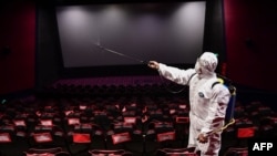 辽宁省沈阳市一家电影院的工人在给影院喷洒消毒液准备重新开业。（2020年3月25日）