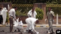 Petugas forensik mengumpulkan barang bukti di lokasi ledakan bom bunuh diri di ibukota Sana'a, yang menewaskan 96 tentara Yaman, Senin (21/5).