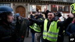 Des manifestants font face à des policiers anti-émeute lors d'une manifestation près de l'Opéra, le 15 décembre 2018 à Paris.