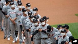 Para pemain bisbal dari tim "Hanwa Eagles" berbaris sambil mengenakan masker saat akan bertanding dengan SK Wyverns di Incheon, Korea Selatan, 5 Mei 2020. 