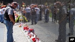 Visitor reading the names on the memorial wall