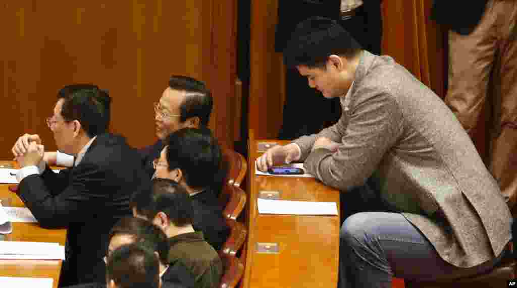 Yao Ming, former NBA basketball star and a delegate to the Chinese People&#39;s Political Consultative Conference, looks at his phone during the closing ceremony of the CPPCC in Beijing&#39;s Great Hall of the People, China. 