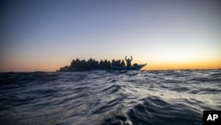 FILE - Migrants and refugees from various African countries aboard a wooden boat in the Mediterranean Sea. 