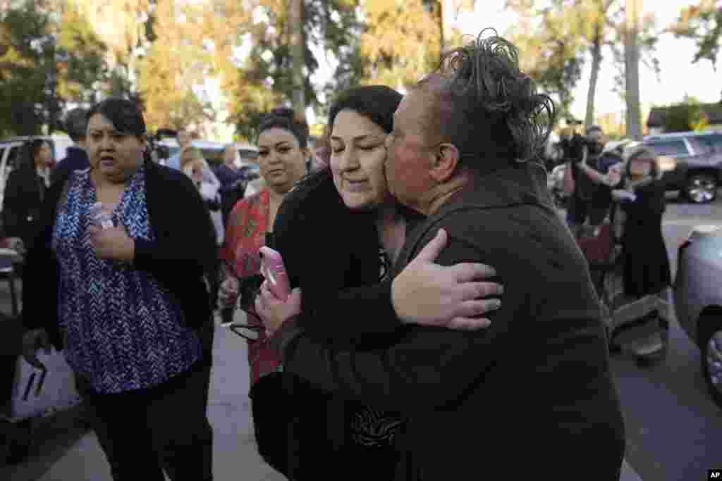 A woman who declined to give her name kisses her sister, center, a survivor of a shooting rampage that killed multiple people and wounded others as they reunite at a community center in San Bernardino, Dec. 2, 2015.