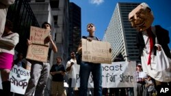 Protesters demonstrate across the street from the Comcast Center Monday, Sept. 15, 2014, in Philadelphia. Demonstrators opposed the proposed merger of Comcast Corp. and Time Warner Cable Inc., and called for support of "net neutrality." (AP Photo/Matt Rourke)