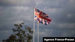 This photograph taken on Dec. 10, 2021, shows the Britain flags wave, in the harbor of Ouistreham, northwestern France. 