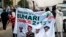 All Progressives Congress (APC) supporters hold a banner with a photograph of former military ruler Muhammadu Buhari in Lagos, Nigeria, Dec. 10, 2014.