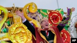 FILE - Actor Bryan Cranston waves beads as he acts as the celebrity monarch of the Krewe of Orpheus along the Uptown parade route during Mardi Gras celebrations in New Orleans, on Feb. 24, 2020.