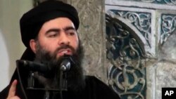 This file image made from video posted on a militant website July 5, 2014, purports to show the leader of the Islamic State group, Abu Bakr al-Baghdadi, delivering a sermon at a mosque in Iraq.