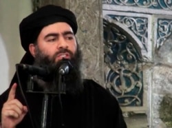 This file image made from video posted on a militant website July 5, 2014, purports to show the leader of the Islamic State group, Abu Bakr al-Baghdadi, delivering a sermon at a mosque in Iraq.