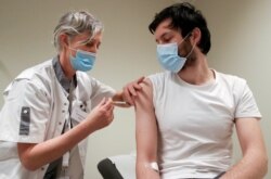 FILE - A volunteer receives a dose of CureVac vaccine or a placebo during a study by the German biotech firm CureVac as part of a testing for a new vaccine against the coronavirus disease (COVID-19), in Brussels, Belgium, March 2, 2021.
