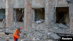 Mfanyakazi akisafisha barabara karibu na jengo la utawala la jiji lililokumbwa na mashambulizi ya hivi karibuni katika mzozo wa Ukraine na Russia, huko Donetsk, inayodhibitiwa na Russia Oktoba 16, 2022. REUTERS.