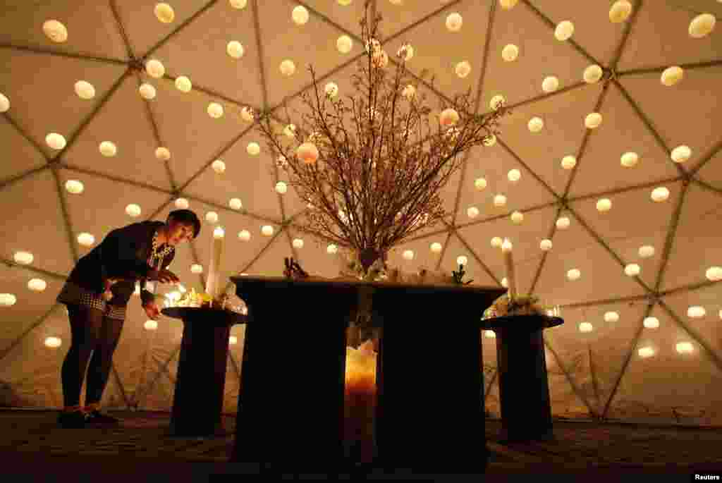 A visitor lights a candle to remember the victims of the March 11, 2011 tsunami and earthquake, in Tokyo, March 10, 2013. 