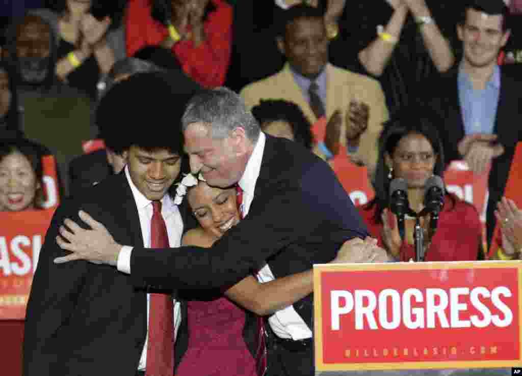 Democratic Mayor-elect Bill de Blasio embraces his son Dante, left, and daughter Chiara, center, after he was elected in Brooklyn, New York, Nov. 5, 2013.