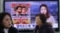 People pass a TV screen showing a news report on Sony Picture's 'The Interview,' at the Seoul Railway Station in South Korea.